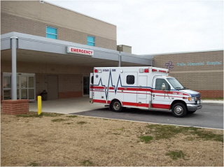 Ambulance sitting outside the entrance of the EMERGENCY DEPARTMENT