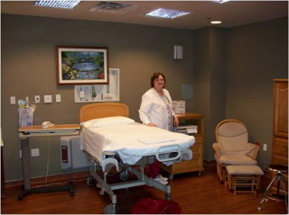Female Nurse standing next to a swing bed in Birthing Suite